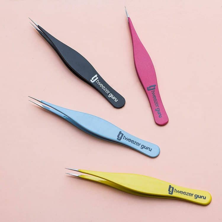 Our best tweezers for removing ingrowns, the Tweezer Guru Point Tip Tweezers. In the photo pointed tip tweezers arranged stylistically. The tweezers from top to bottom are in different colors, pink, black, light blue, yellow. 